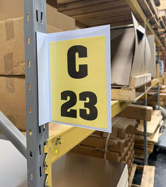 Magnetic warehouse aisle pouch sign on rack upright