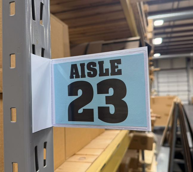 Magnetic warehouse aisle pouch sign on rack upright