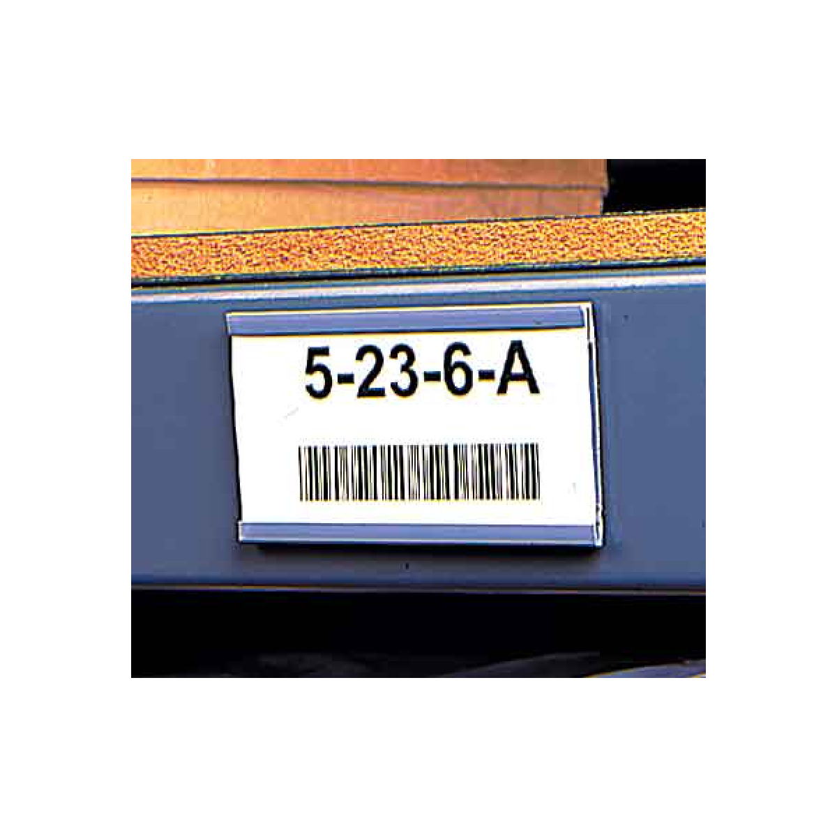 Plastic card holder with magnetic backing on warehouse shelf 